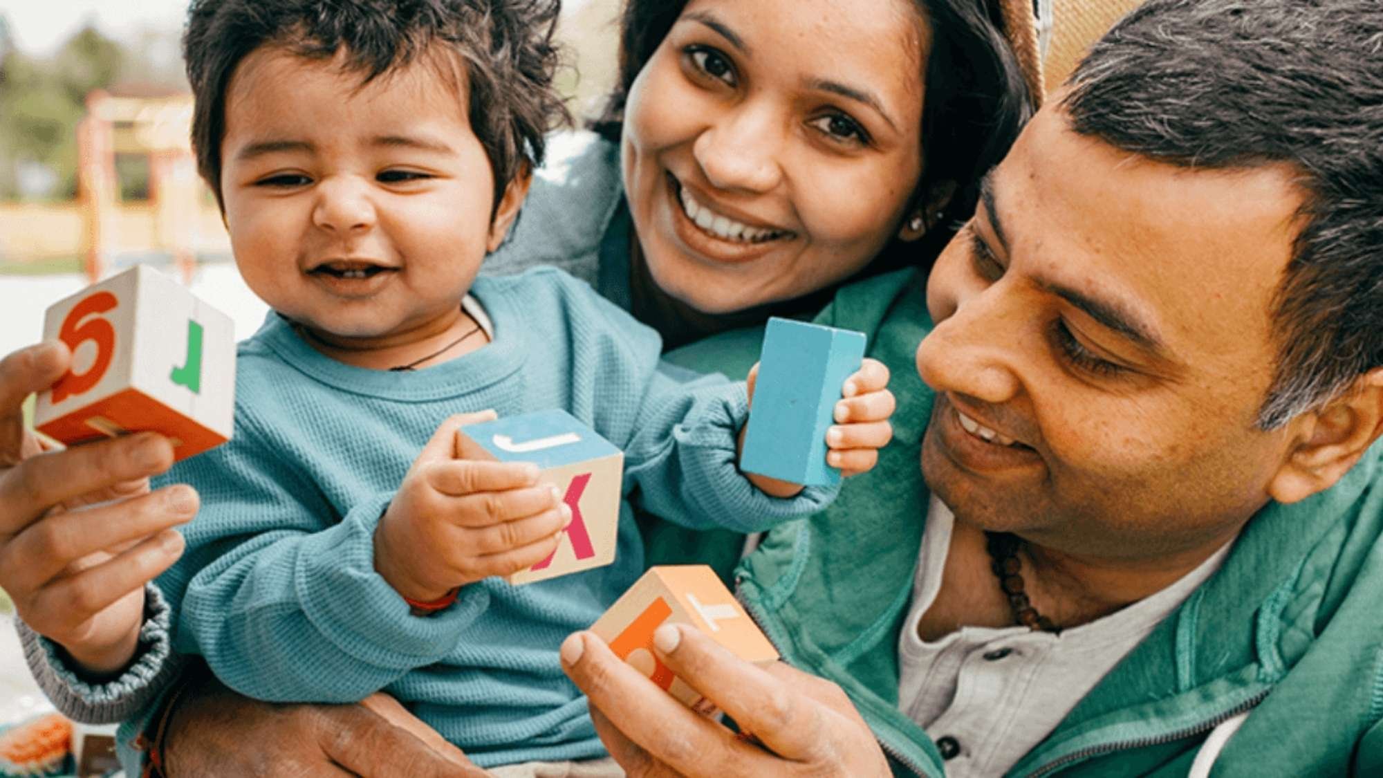 family with child playing with building blocks